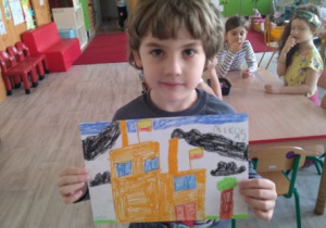 Chłopiec z własnym rysunkiem łódzkiej fabryki